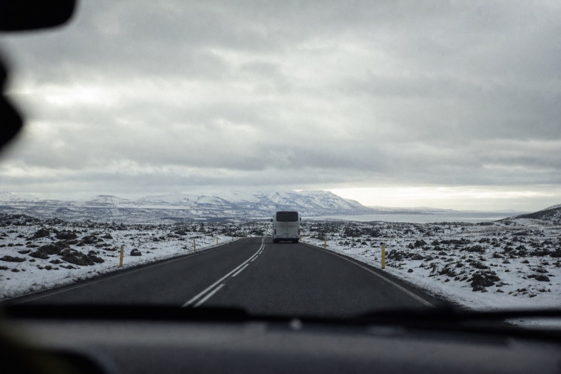 Route 36 crossing snow-covered lava fields toward Þingvellir under a heavy grey sky