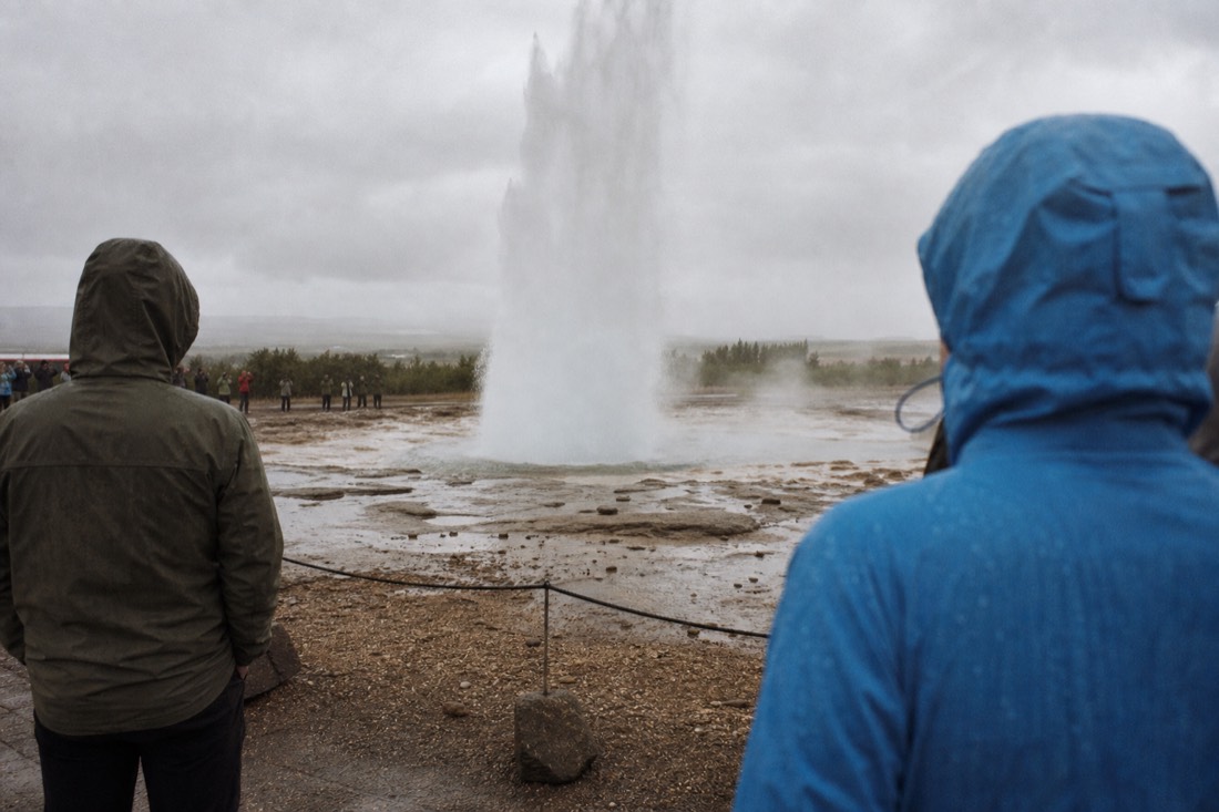 Strokkur bursting into a white column above the Geysir geothermal field