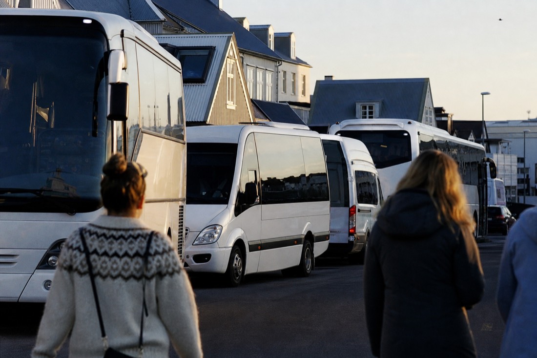 Tour coaches parked near Reykjavík's old harbour in low golden evening light