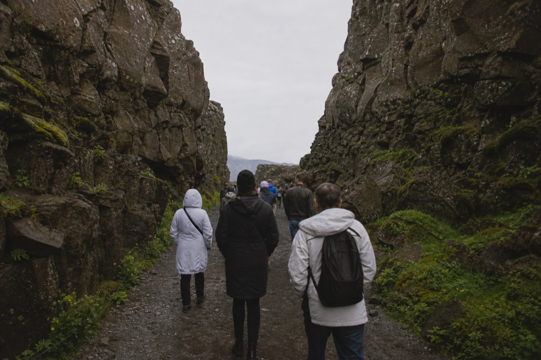 Walkers on the Almannagjá rift path at Þingvellir between high basalt walls