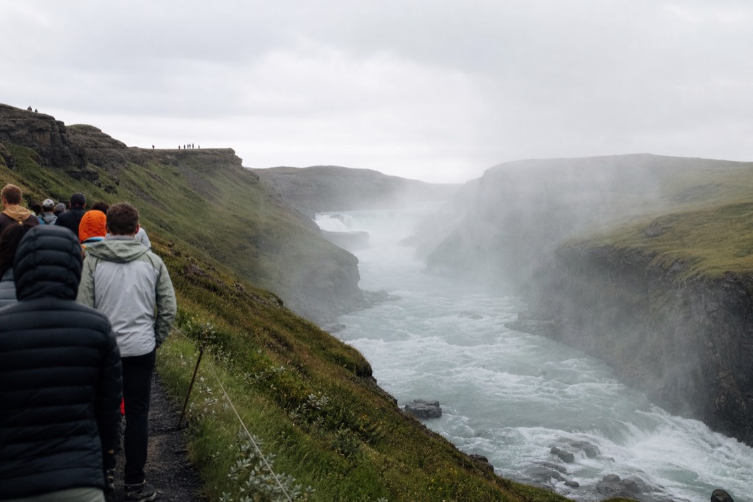 View along the rim of the Hvítá river canyon below Gullfoss with mist hanging over the gorge