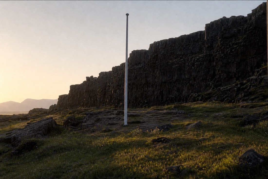 The flagpole marking the Lögberg law rock area at Þingvellir with the gorge wall behind it in low golden evening light
